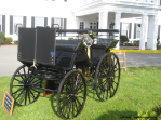 Antique car in front of white mansion